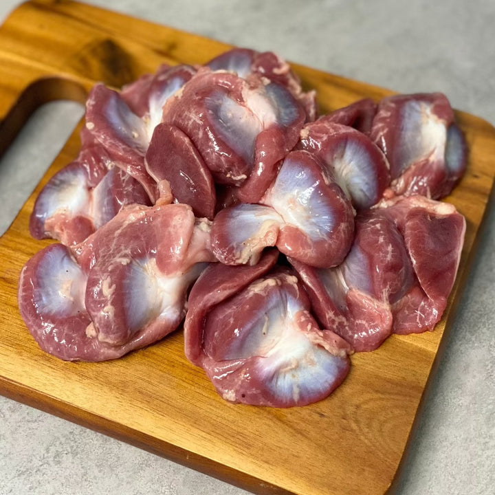 Pasture raised chicken gizzards on a cutting board.